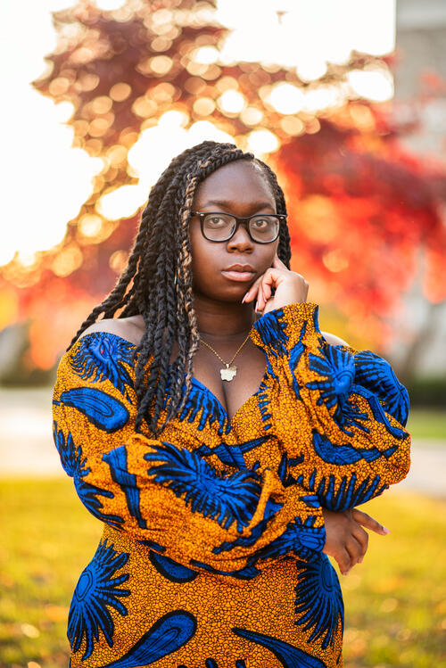 girl posing in front of red tree